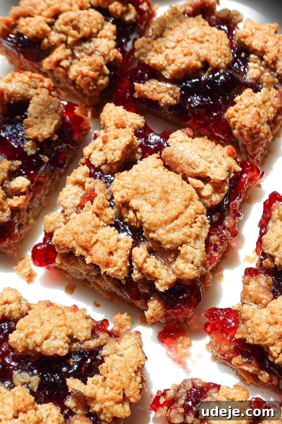 Close-up of a soft, chewy PB&J bar with golden oat crust and jammy center