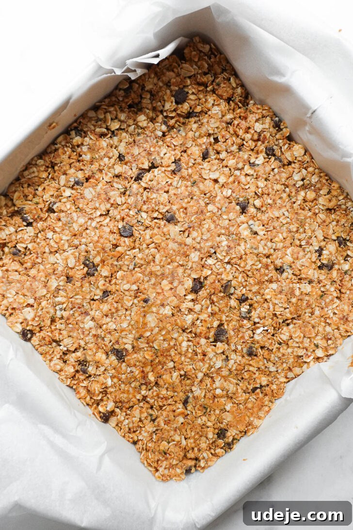 Nourishing Plant-Based Gluten-Free Granola Bars 6 Another angle of the granola bar mixture firmly pressed into the lined pan, demonstrating proper compaction before refrigeration