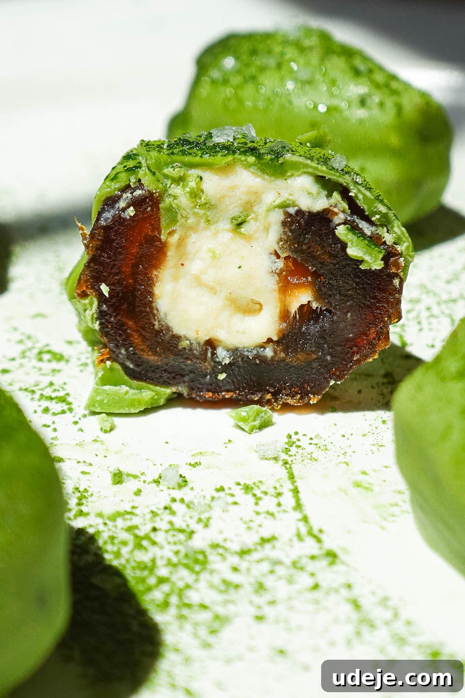 Matcha Date Delights 5 Matcha stuffed date cut in half showing creamy vegan yogurt filling and vibrant matcha white chocolate shell
