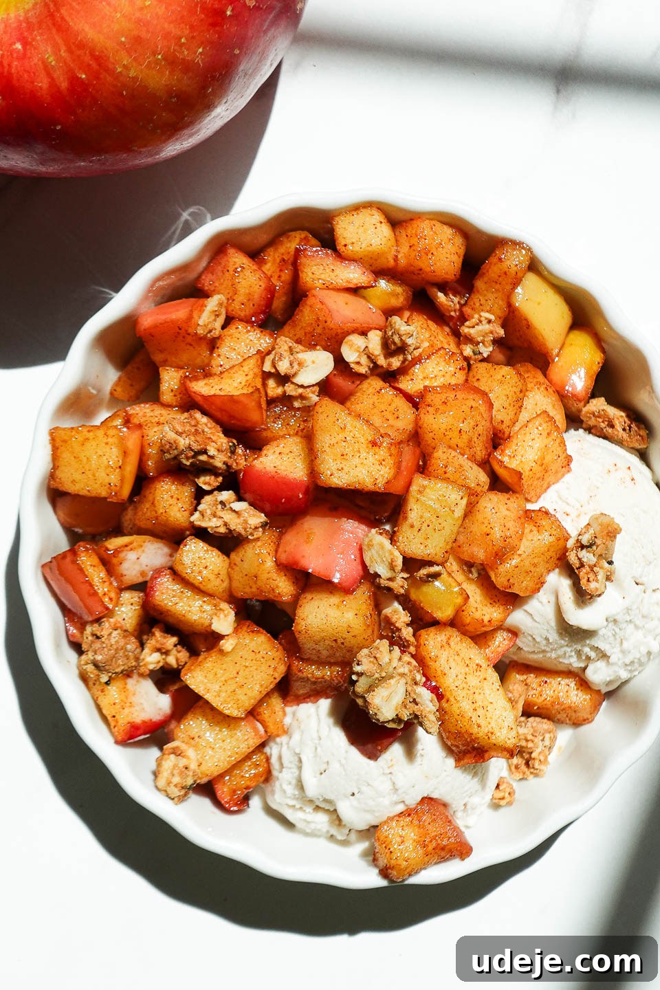 Air Fried Cinnamon Apples 2 Bowl of warm cinnamon air fryer apples sprinkled with granola and served with vegan vanilla ice cream