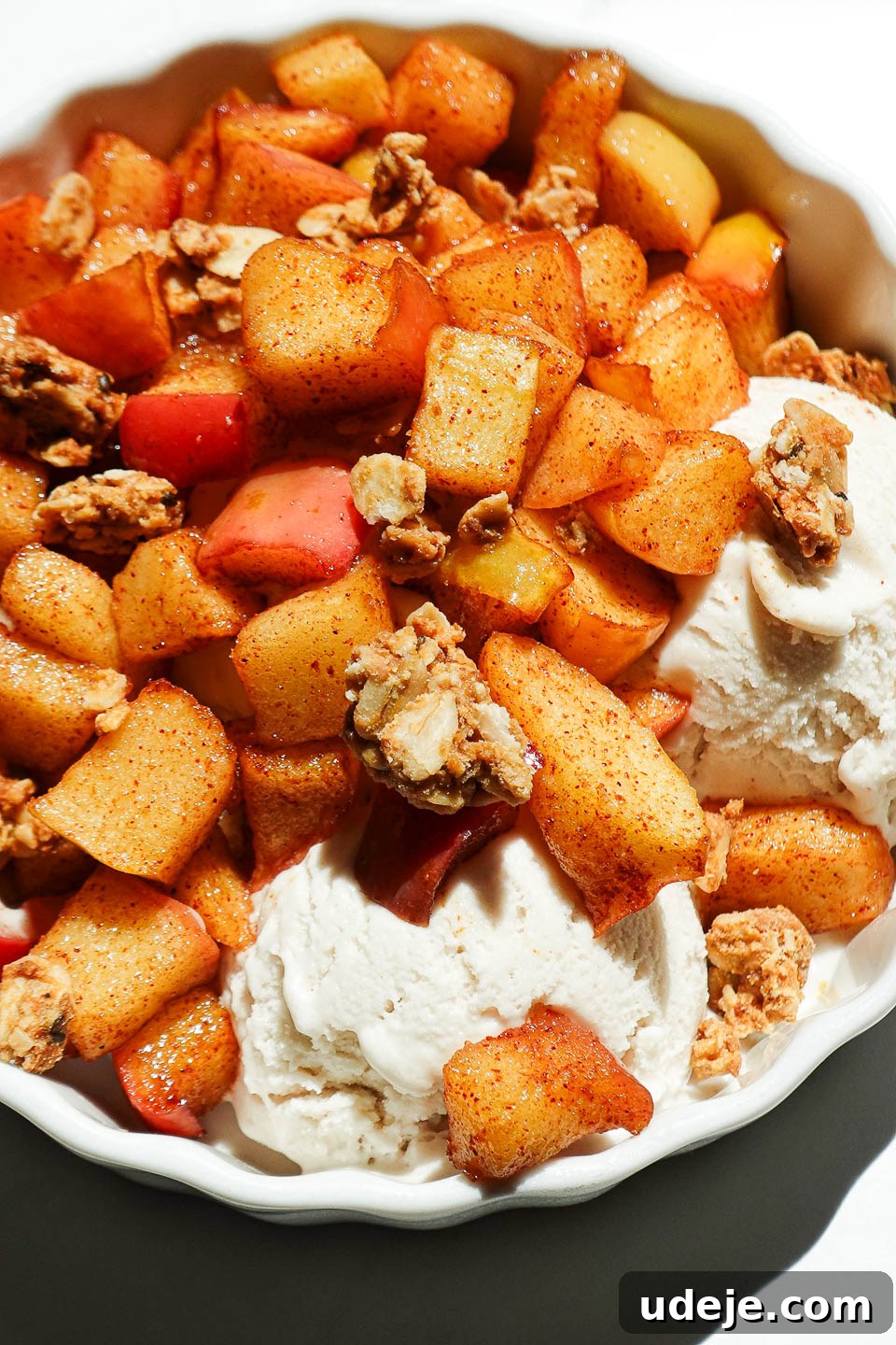 Air Fried Cinnamon Apples 5 Close-up of air fryer apples topped vanilla ice cream and a sprinkle of crunchy granola
