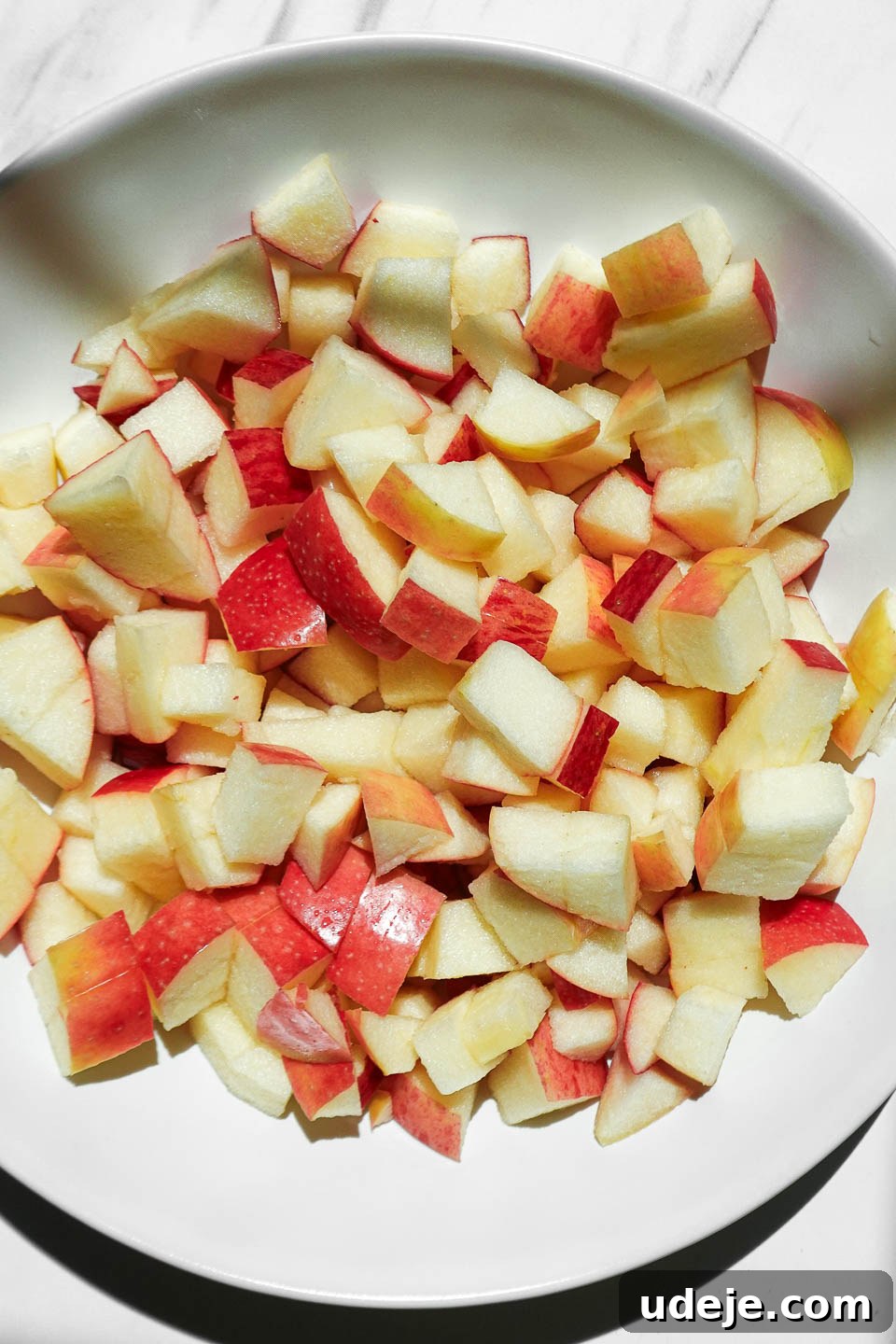 Air Fried Cinnamon Apples 6 Freshly diced apples in a bowl ready to be tossed with maple syrup and cinnamon