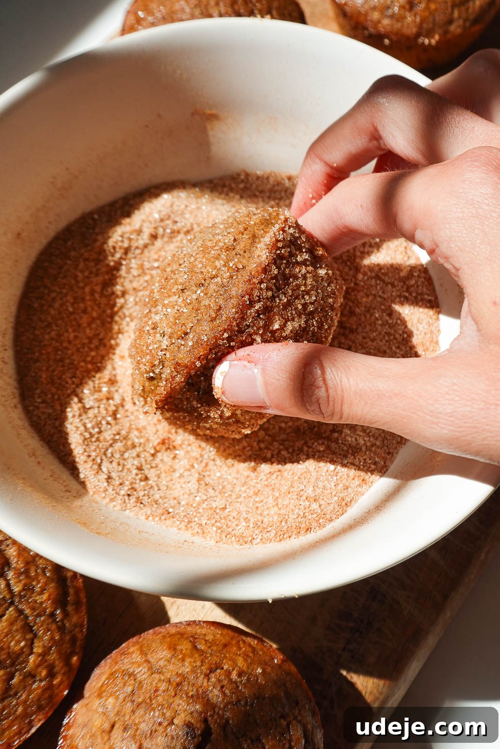 Autumn Spiced Apple Cider Muffins 8 Freshly baked apple cider muffins being rolled in cinnamon sugar