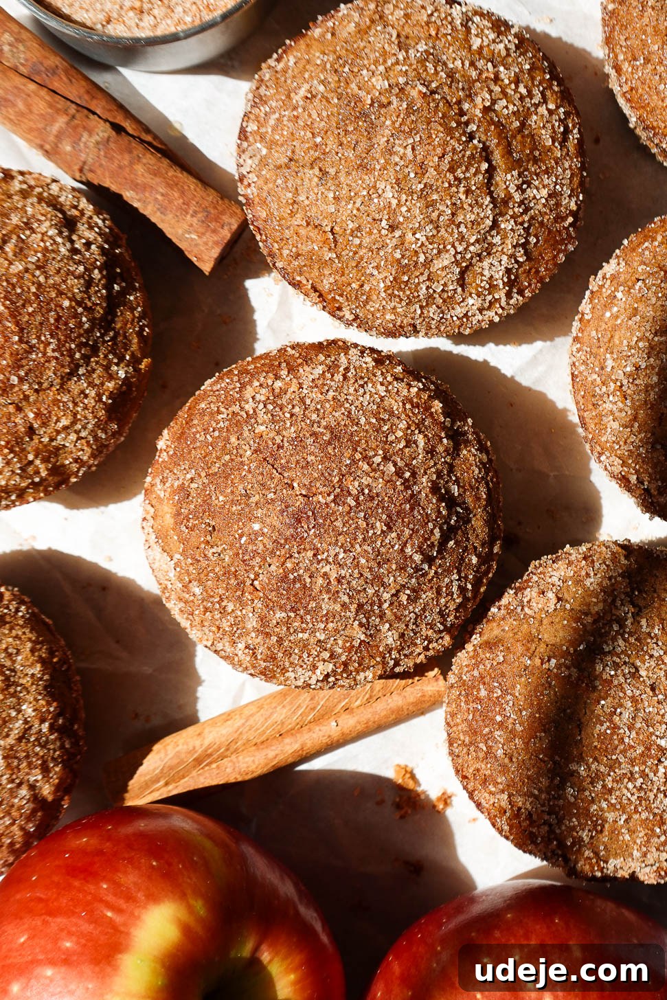Autumn Spiced Apple Cider Muffins 9 Healthy apple cider muffins on a white plate with cinnamon sticks