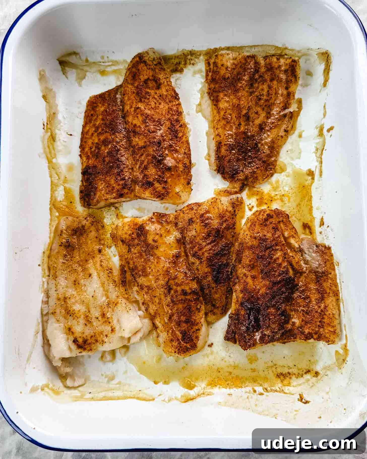 Samke Harra: Lebanon's Signature Spicy Fish 8 Cooked fish coated in orange coloured spices in a white baking dish with a dark blue rim.