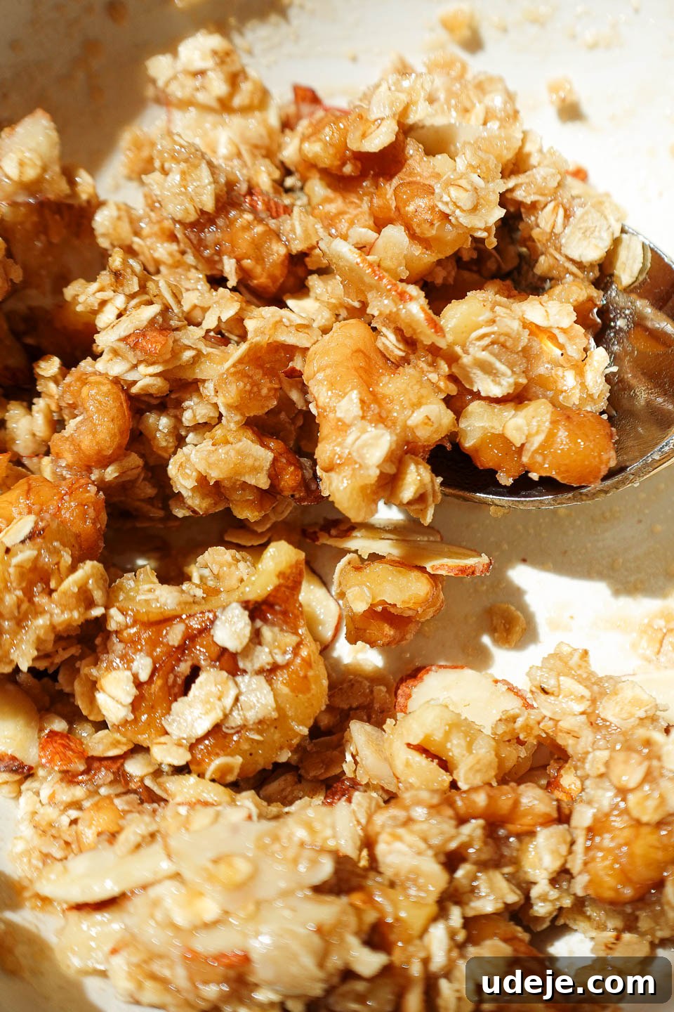 Golden Apple Crisp Date Bites 5 Mixing oat crisp topping with walnuts and maple syrup in a small bowl, showing the crumbly texture.