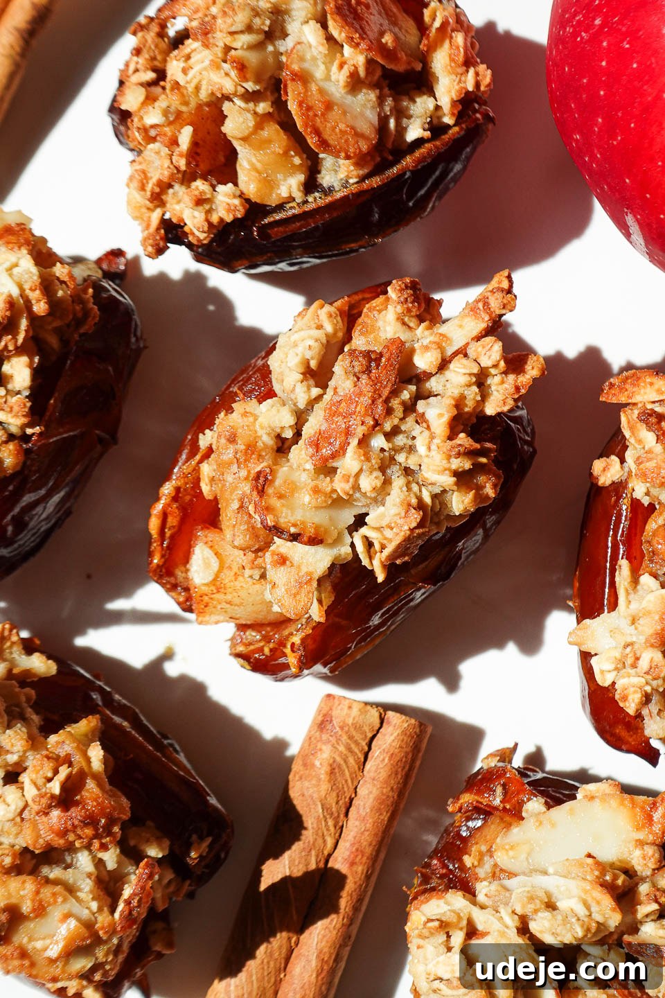 Golden Apple Crisp Date Bites 7 Apple crisp stuffed dates on a plate topped with oat crumble and golden from the air fryer, ready to be served.