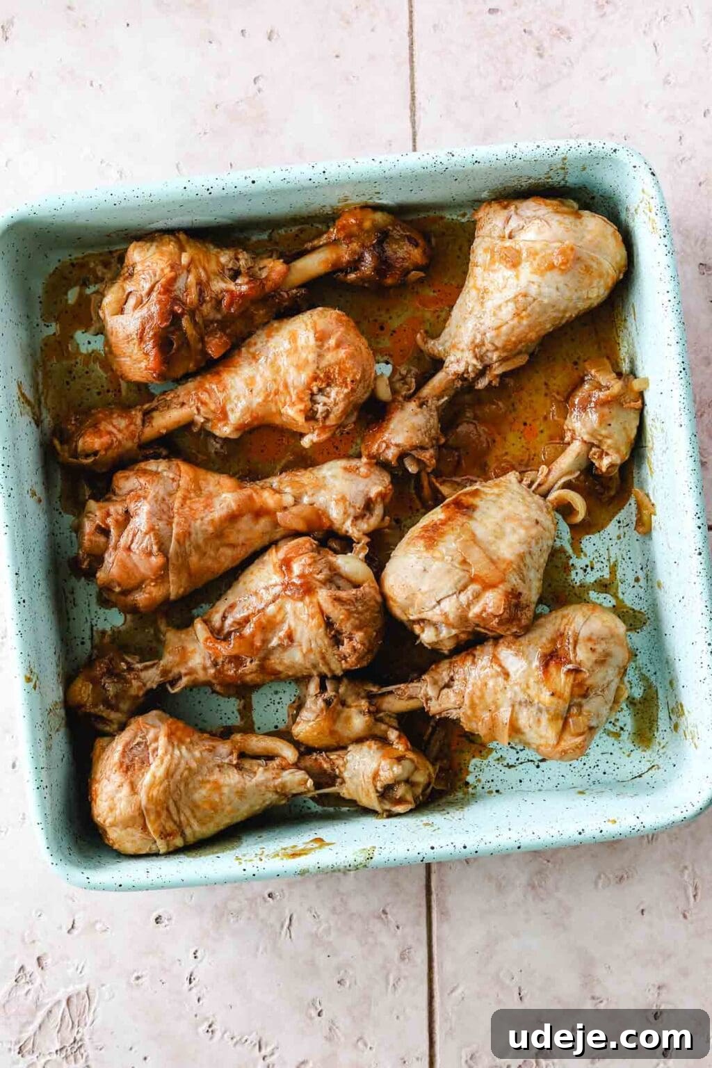 Machboos and Kabsa Aromatic Chicken and Rice 8 Cooked chicken legs in a light blue square pan on a light coloured tiled background