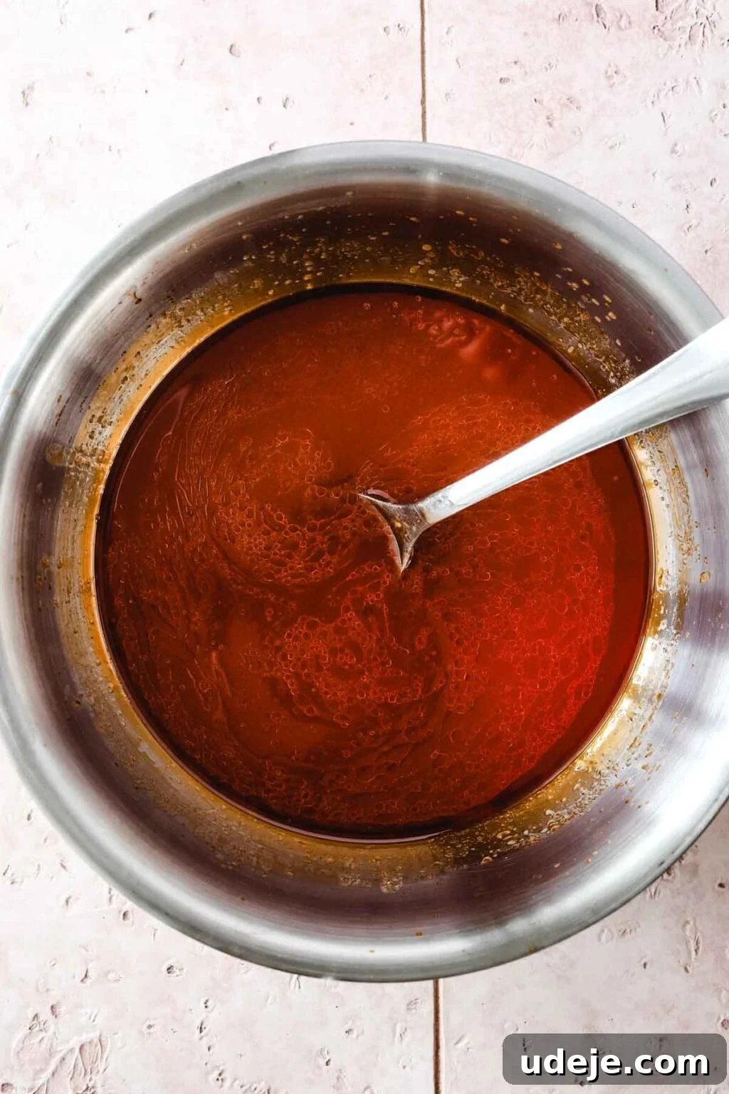 Machboos and Kabsa Aromatic Chicken and Rice 10 Tomato broth in a silver pot with a silver spoon on a light coloured tiled background