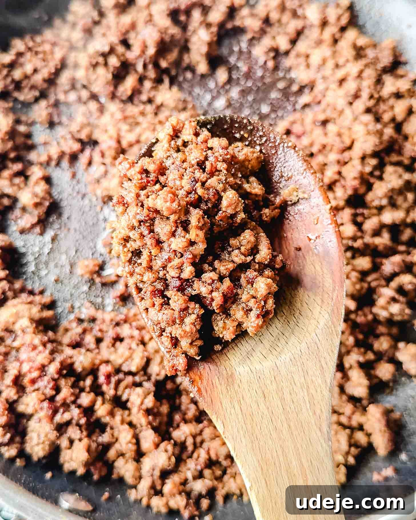 Easy Middle Eastern Spiced Beef Bowls 5 Fully cooked and browned ground beef with crispy bits in a dark colored skillet, a wooden spoon resting in the pan.