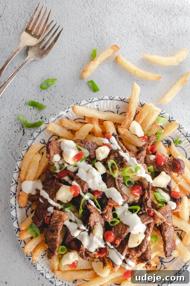 Shawarma Beef Poutine Twist 2 Beef shawarma poutine served in a plate with someone about to dig in using a fork