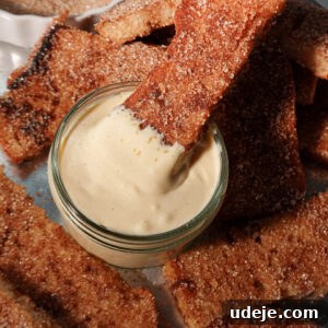 Spiced Vegan Gingerbread French Toast 8 Close-up of a gingerbread French toast stick being dipped into creamy vanilla vegan yogurt