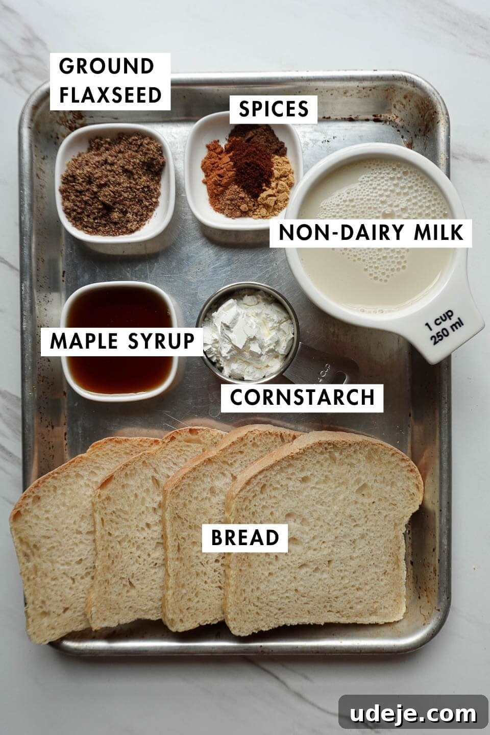 Spiced Vegan Gingerbread French Toast 3 All ingredients neatly laid out on a rustic wooden table for making vegan gingerbread French toast sticks, including milk, spices, bread, and syrup