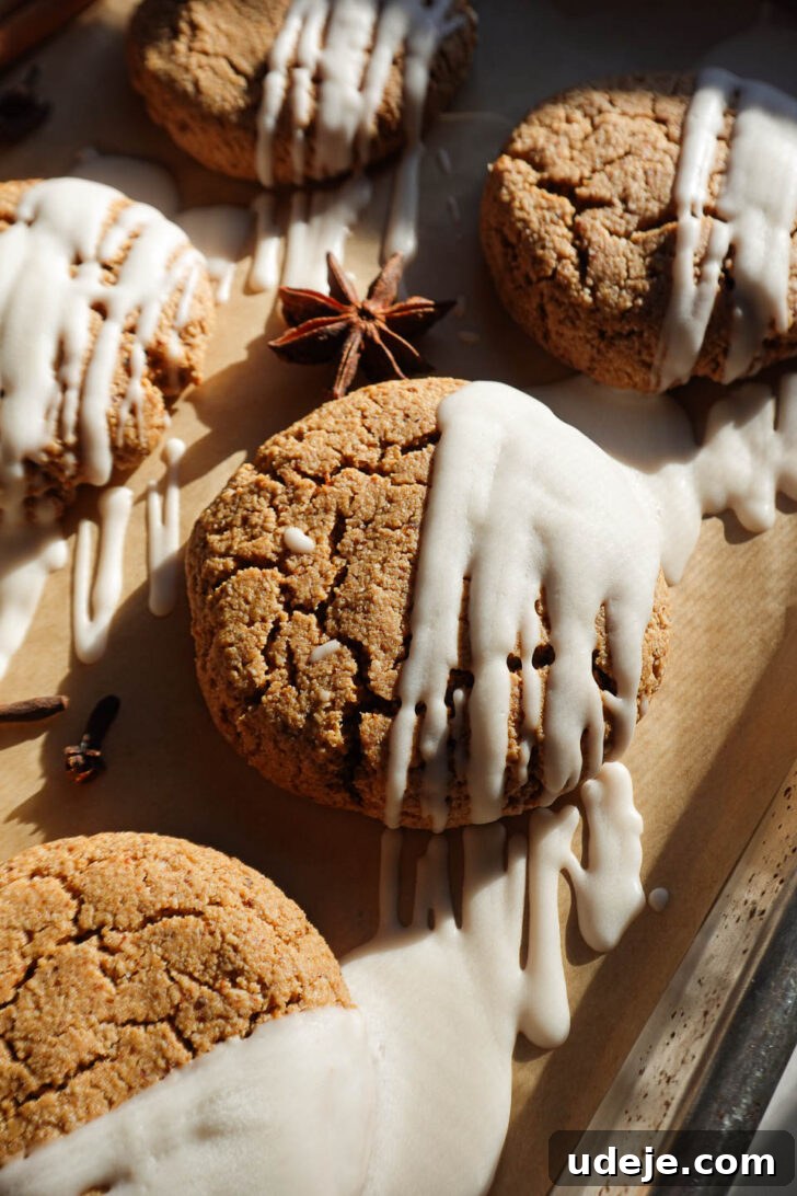 Irresistible Vegan Gluten-Free Gingerbread Chews 7 Soft and chewy gingerbread cookies drizzled with vegan white chocolate on a parchment-lined tray.