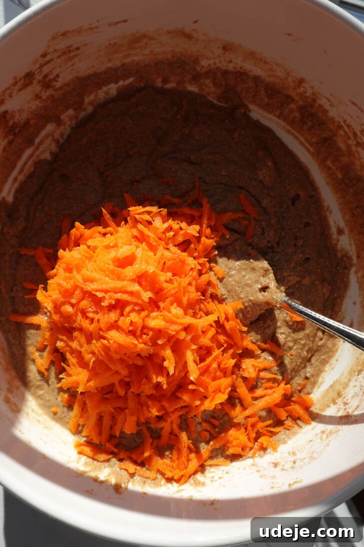 Wholesome Vegan Gluten Free Carrot Cake Muffins 7 Mixing freshly grated carrots into one-bowl carrot cake muffin batter before baking