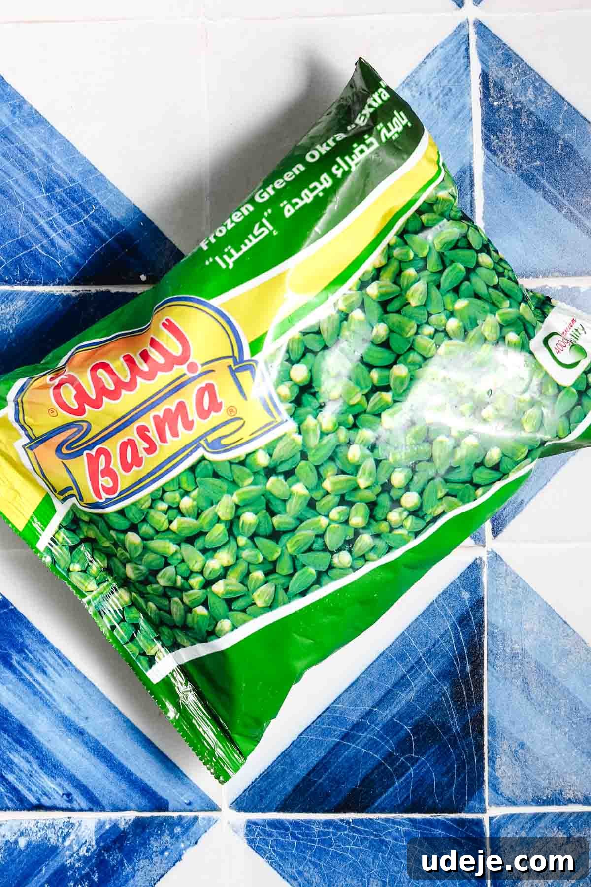 Flavorful Middle Eastern Bamya Okra Stew 4 A package of frozen green okra resting on a blue and white tiled patterned background, ready for use in cooking.