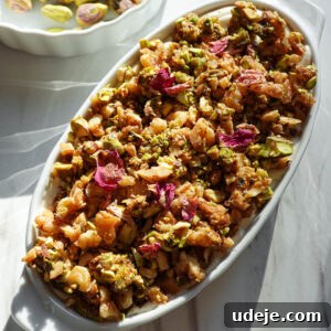 Baklava overnight oats topped with creamy vegan yogurt, pistachios, walnuts, and dried rose petals