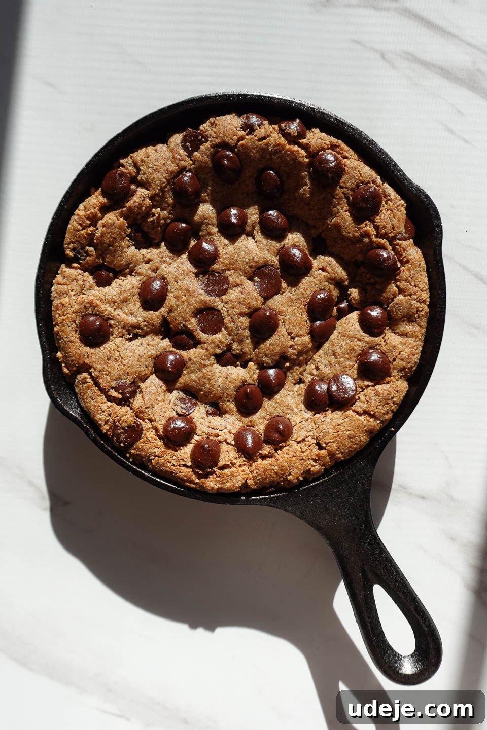Gooey Skillet Chocolate Chip Cookie Perfection (Vegan and Gluten-Free) 10 Baked chocolate chip cookie skillet with perfectly set edges and a soft, gooey center, fresh from the oven.