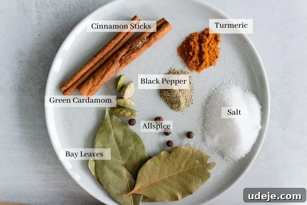 The Perfect Upside-Down Lamb Maqluba (Makloubeh) 4 Various whole and ground spices for Maqluba: cinnamon sticks, green cardamom pods, bay leaves, whole allspice, salt, black pepper, and ground turmeric.