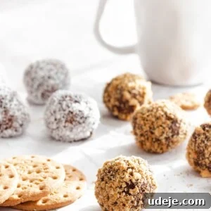 Biscuit balls on parchment paper with a white coffee mug in the back and digestive biscuits on the left side