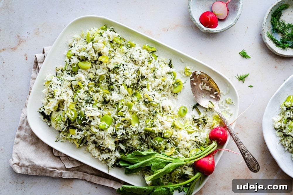Fragrant Dill and Fava Bean Pilaf 4 A large serving of Baghali Polo (Dill Rice) with fresh dill and fava beans, on a white plate, ready to be enjoyed.