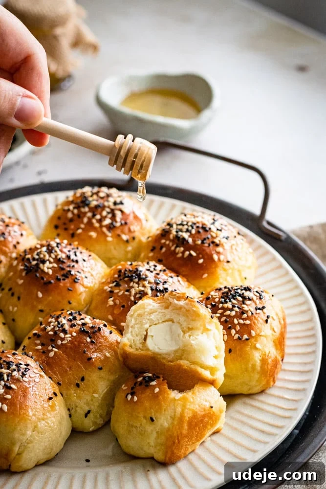 Cheesy Honeycomb Pull-Apart Bread 6 A hand gently drizzles golden honey over warm, freshly baked Honeycomb Bread, highlighting its rich color and inviting texture.