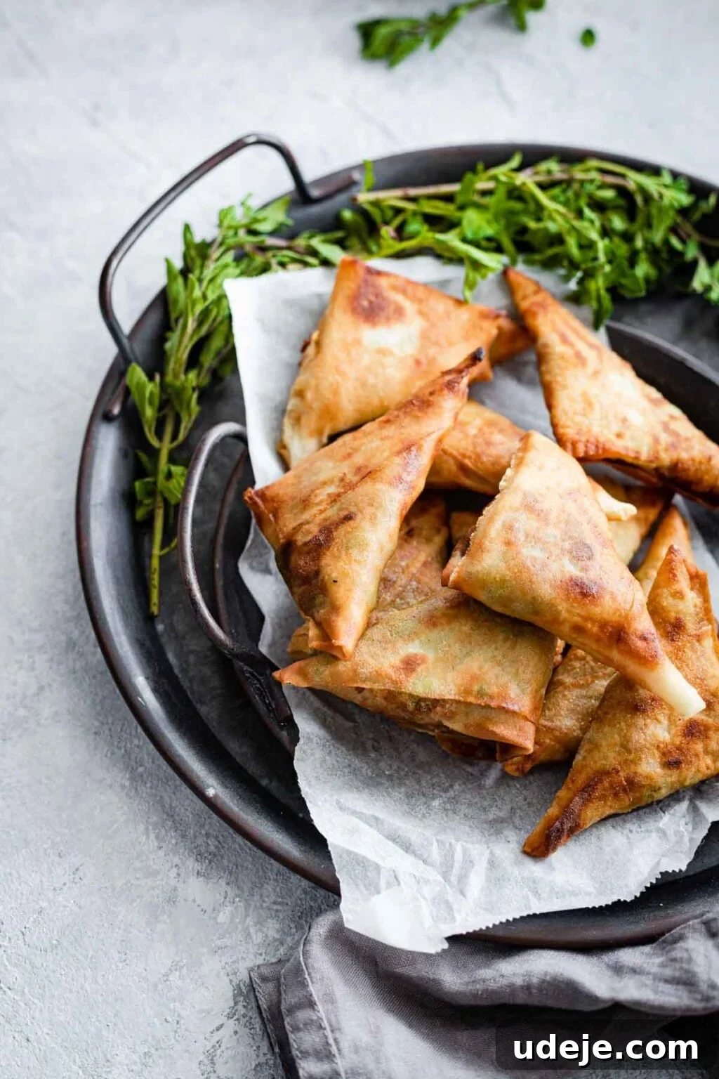 Your Guide to Authentic Homemade Sambousek 25 Vegetarian sambousak served on a tray garnished with greens