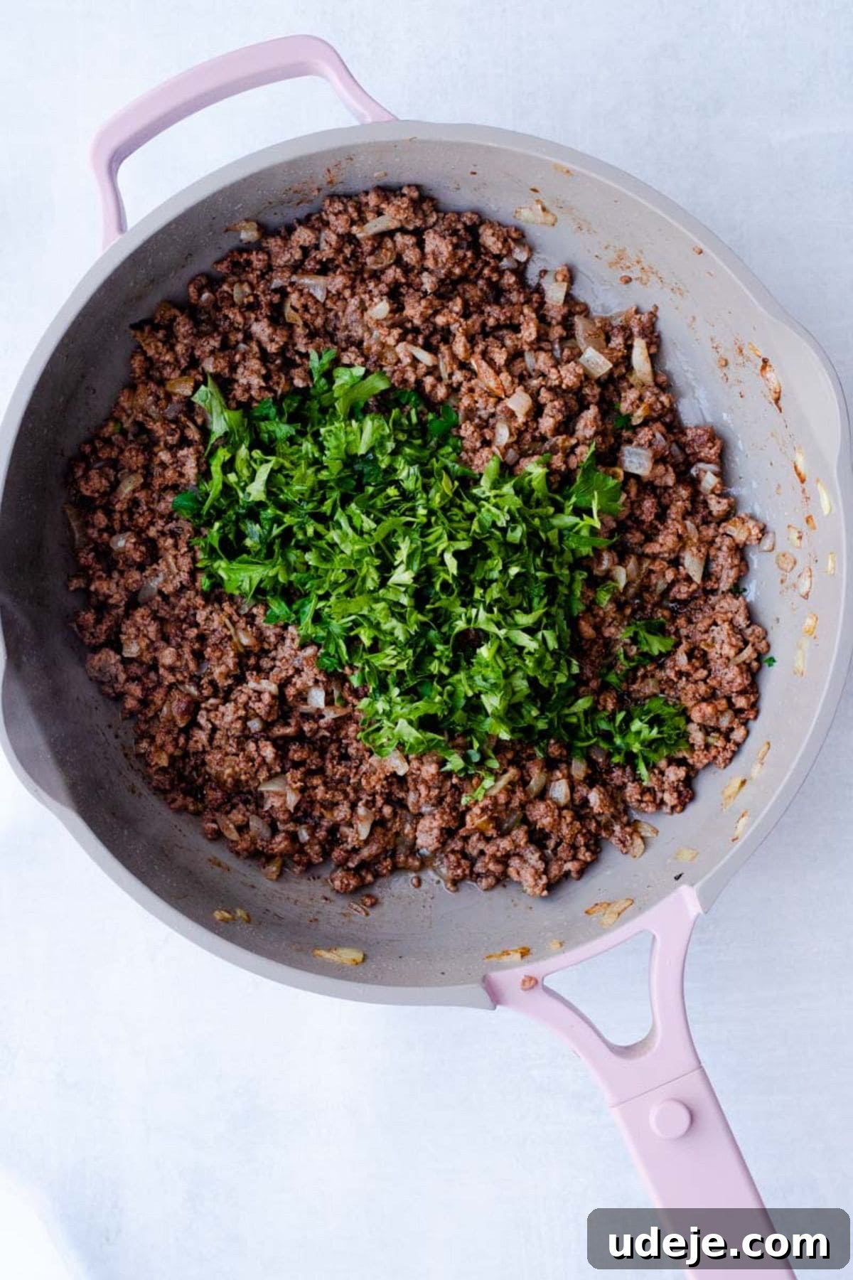 Your Guide to Authentic Homemade Sambousek 7 cooked ground beef with onions in a pan, with finely chopped parsley on top