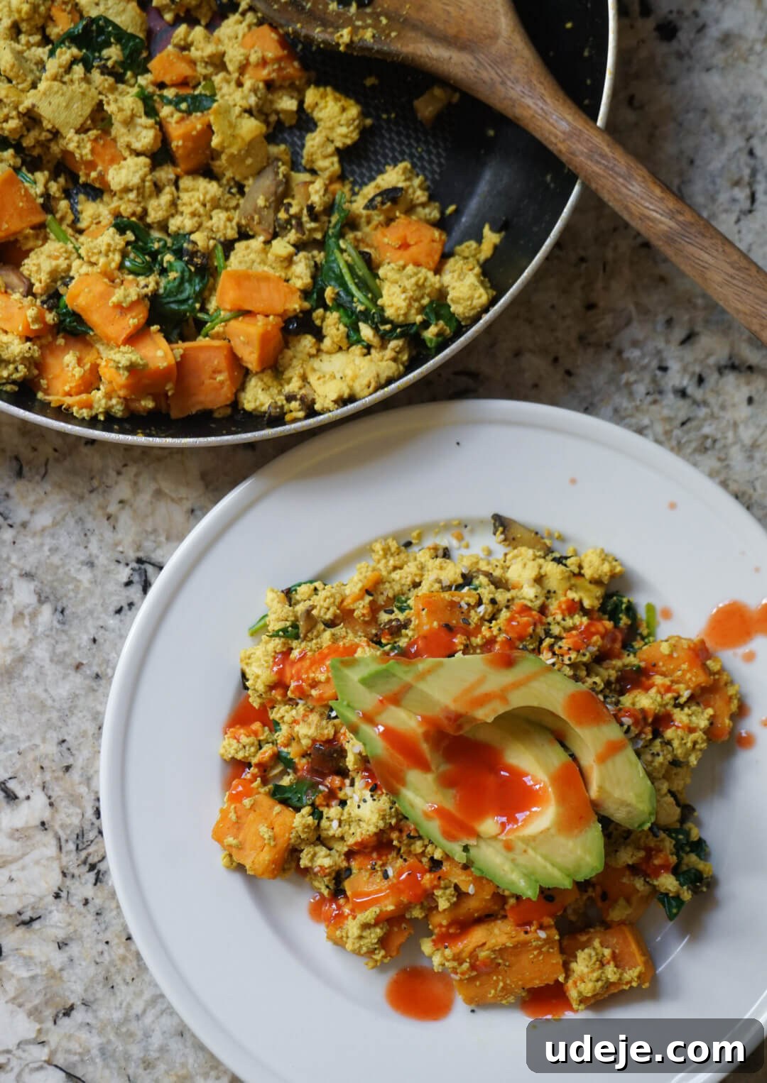Next-Level Tofu Scramble 4 Beautifully plated vegan tofu scramble on toast, garnished with fresh herbs and a drizzle of sauce.