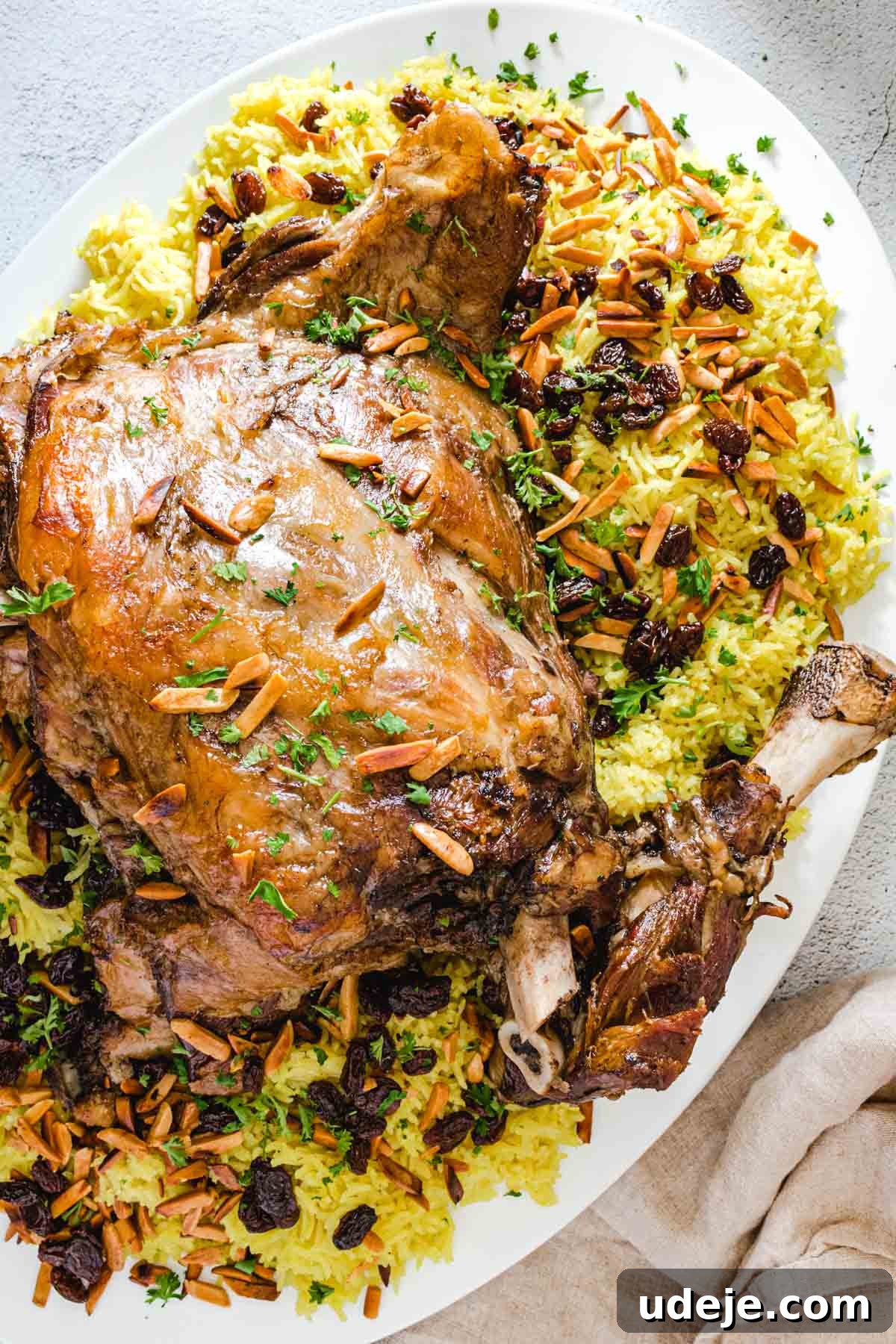 Authentic Iraqi Quzi: Slow-Cooked Lamb on Aromatic Rice 3 Quzi which is a lamb shoulder served over yellow rice with almonds and raisins