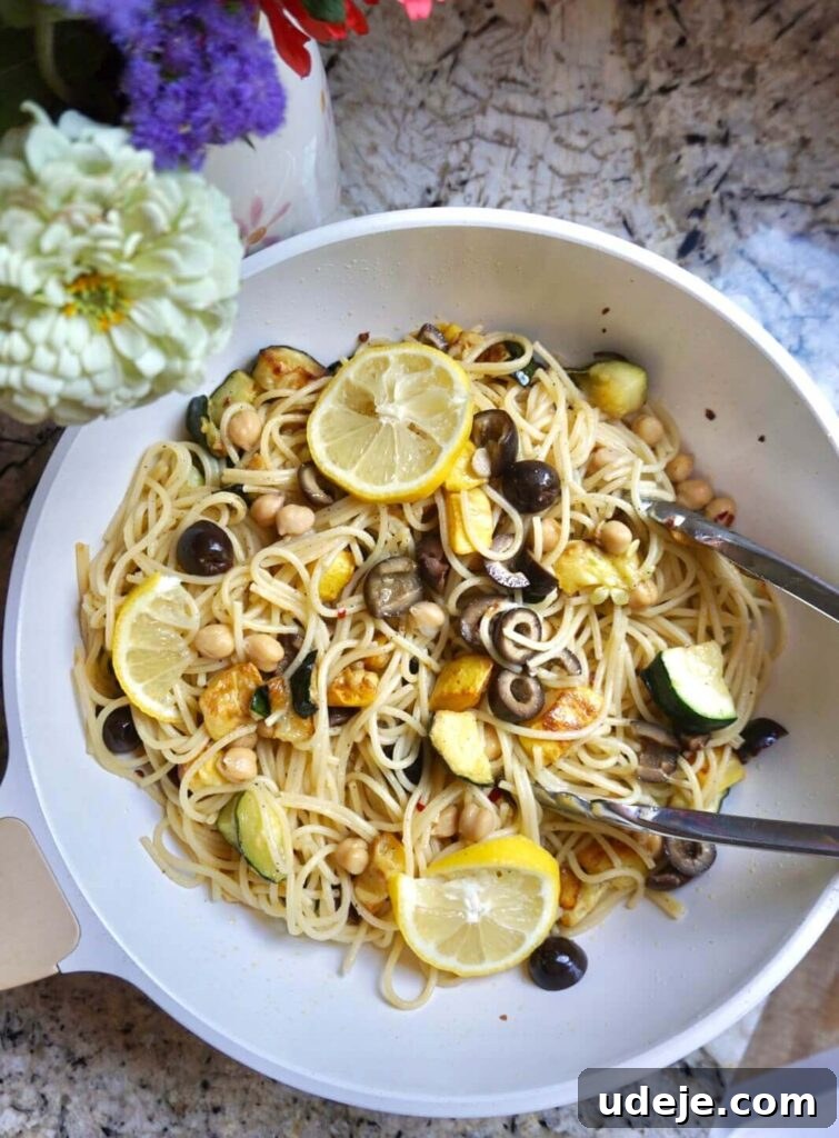 Vibrant Summer Squash Pasta 2 A beautifully plated dish of Vegan Summer Squash Pasta, showcasing fresh zucchini, yellow squash, chickpeas, and black olives, garnished with fresh parsley and lemon slices. The pasta is light, bright, and vibrant, perfect for a healthy summer meal.