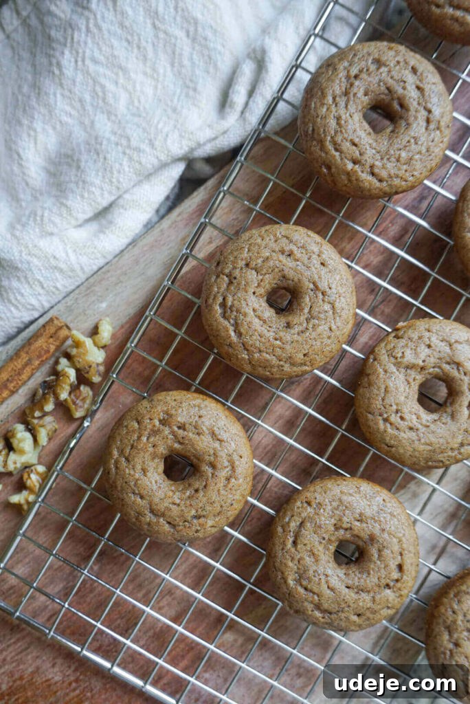 Chai-Spiced Vegan Donuts 4 A batch of freshly baked Vegan Chai Donuts cooling on a wire rack, ready for icing.