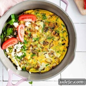 Lazy Sunday Potato Omelette 7 Fluffy potato omelette served in a pan garnished with sliced tomatoes