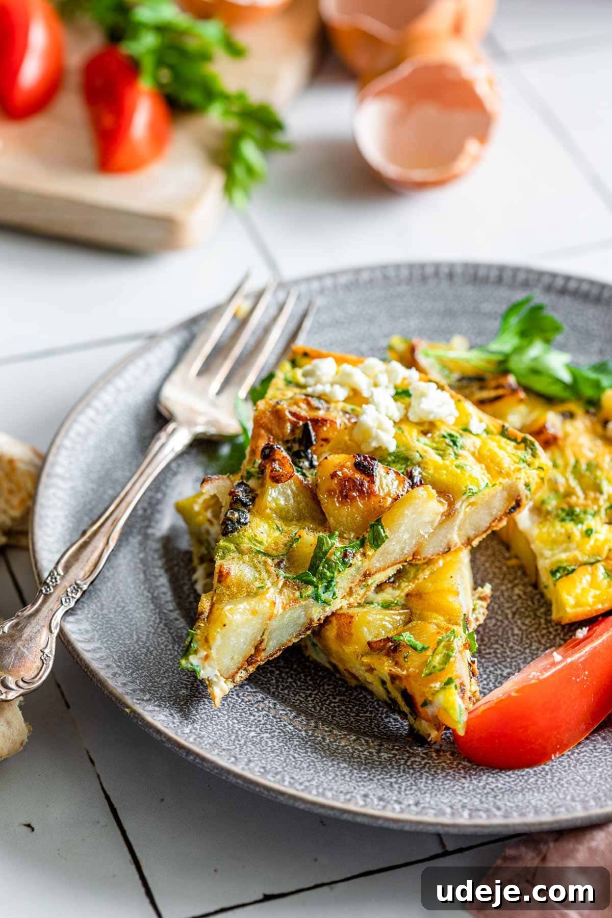 Lazy Sunday Potato Omelette 6 Perfectly sliced potato frittata pieces, artfully arranged on a plate with a fork, highlighting its fluffy texture and golden crust.
