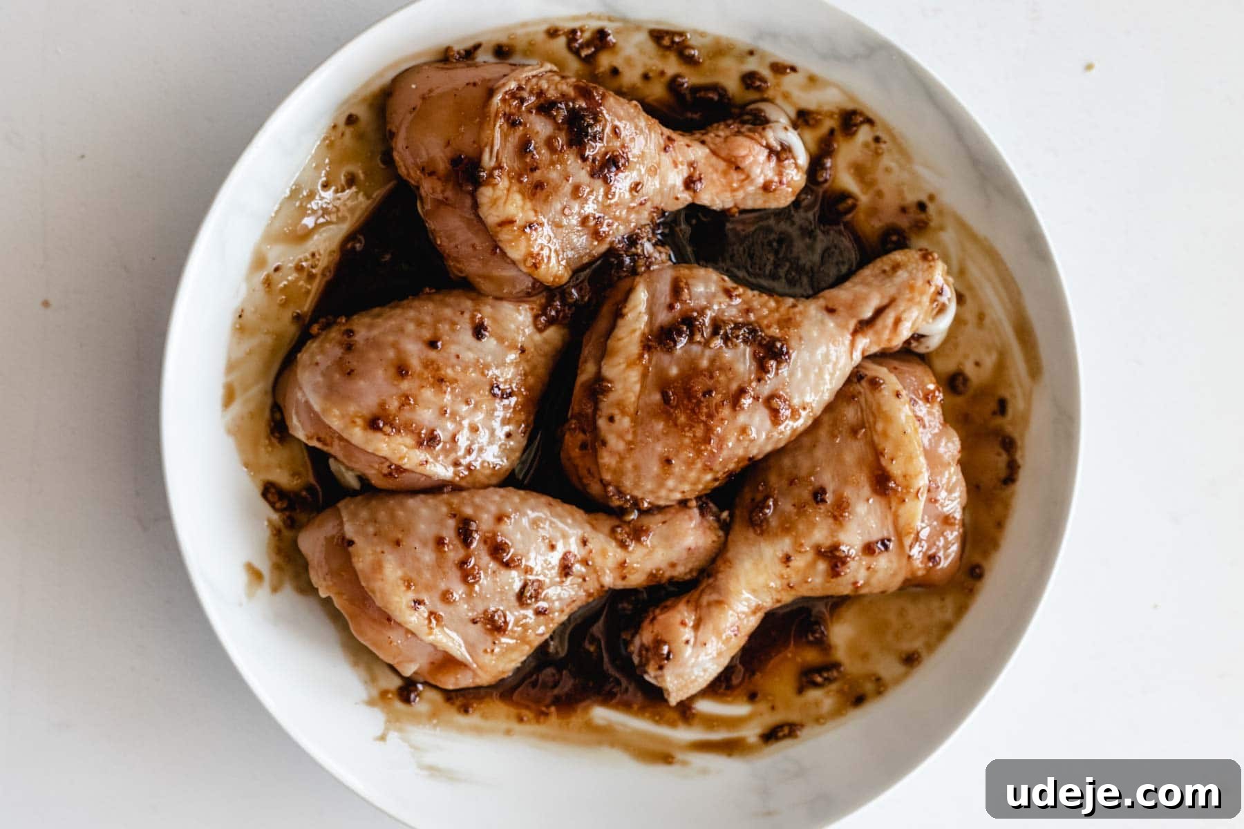 Sticky Pomegranate Air Fryer Drumsticks 5 Marinated chicken drumsticks on a plate, ready for cooking