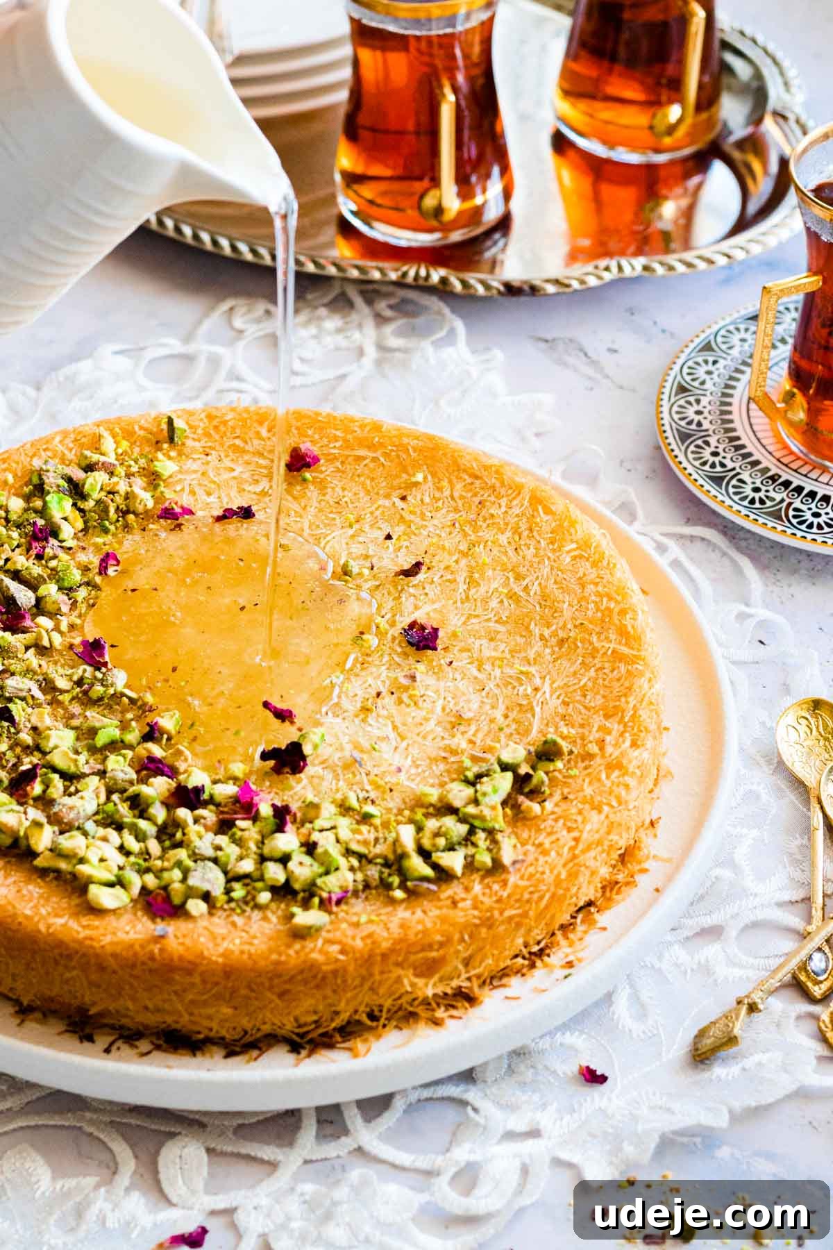 Mozzarella Kunafa Dream Made Simple 2 Golden phyllo dough pastry served on a plate garnished with nuts and drizzled with sugar syrup.