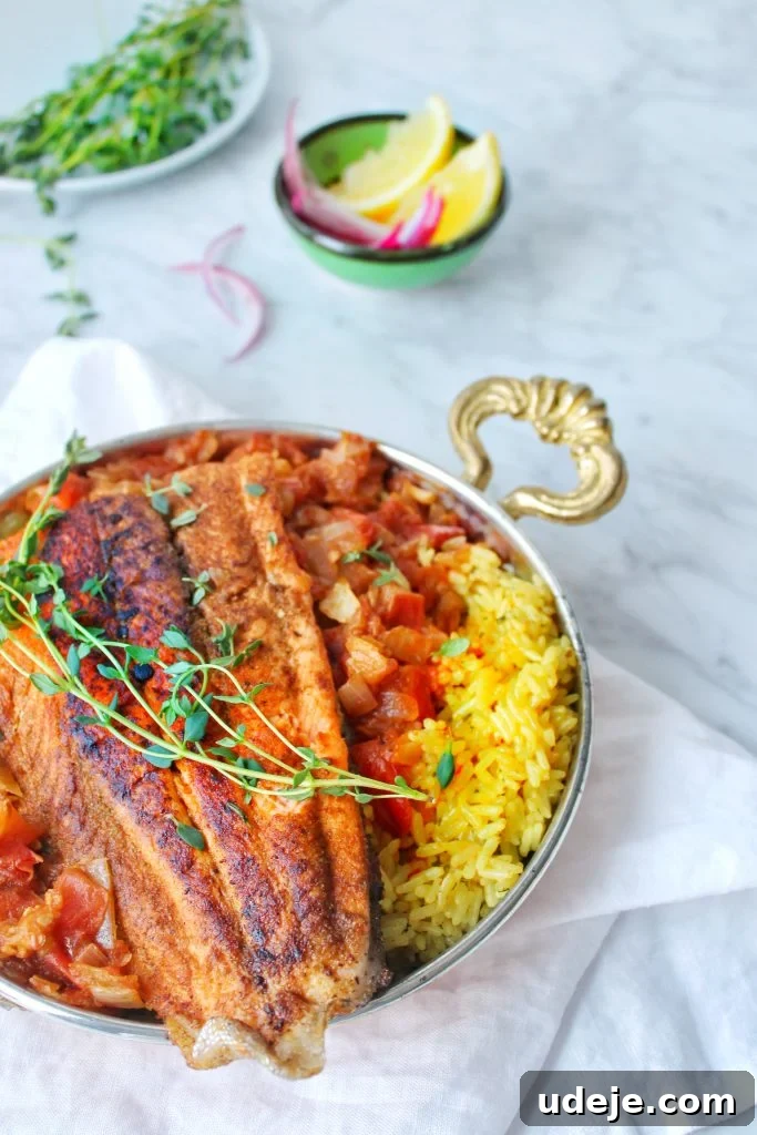 Mediterranean Tomato Fish 2 Arabic fish served on a bed of rice with lemon wedges, onions and thyme