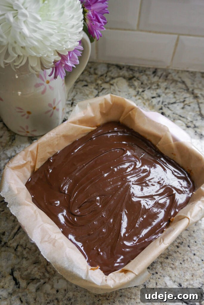 Plant-Based Caramel Cookie Delight 5 The chocolate coating being poured over the Vegan Twix Bars.