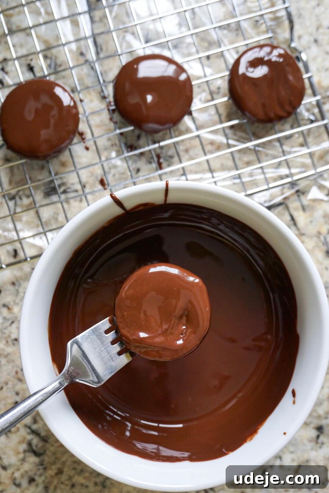 Effortless Vegan Gluten Free Thin Mints 4 A Thin Mint cookie being dipped into a luscious pool of melted vegan chocolate, ensuring full coverage.