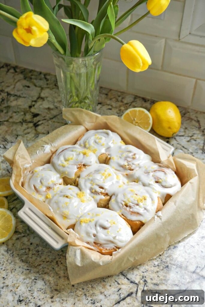 Zesty Vegan Lemon Rolls 9 Close-up of a single Vegan Lemon Sweet Roll with cream cheese frosting and lemon garnish.