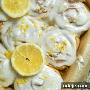 Zesty Vegan Lemon Rolls 10 Close-up of a single Vegan Lemon Sweet Roll with cream cheese frosting and lemon garnish.