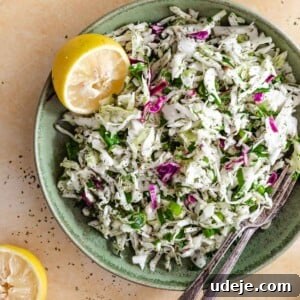 Refreshing Lebanese Cabbage Salad 7 Malfouf salad served in a green plate with lemons and cutlery