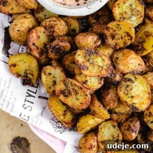 Roasted potatoes in a serving platter with a dipping sauce
