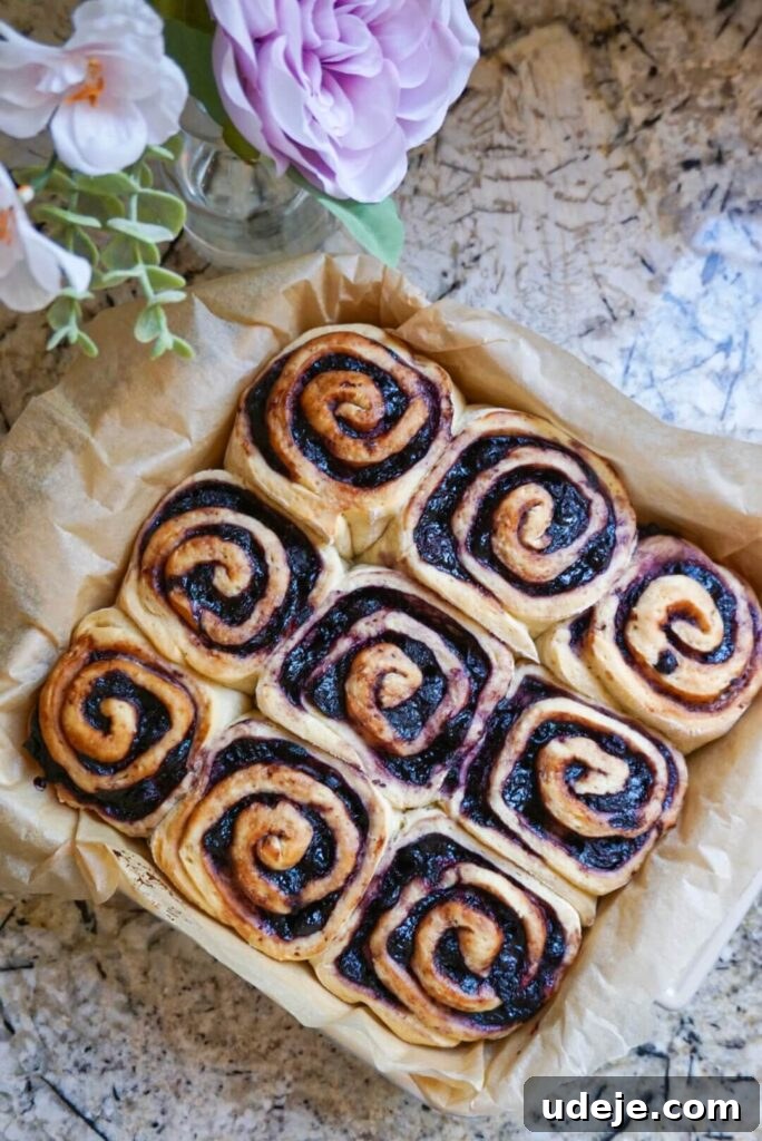 Plant-Based Blueberry Morning Buns 5 Display of a single Vegan Blueberry Roll, showing its moist interior and generous frosting.