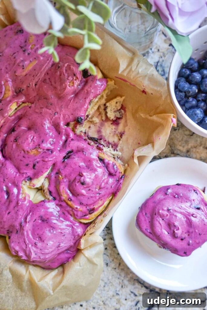 Plant-Based Blueberry Morning Buns 7 A batch of Vegan Blueberry Rolls covered in a rich blueberry cream cheese frosting, ready to be enjoyed.