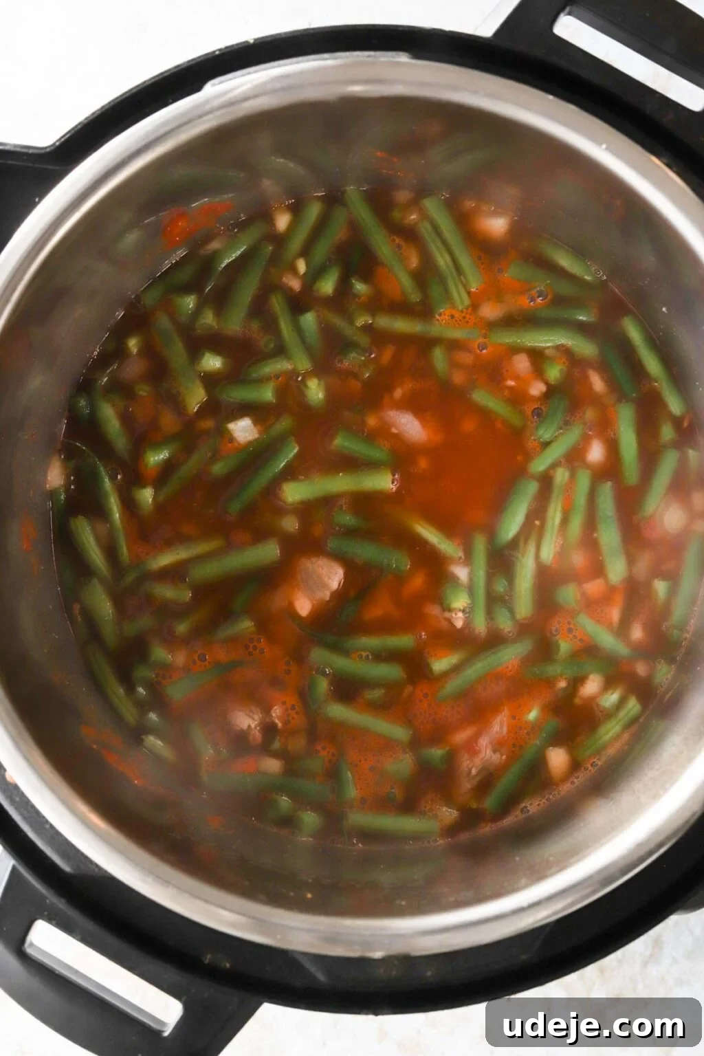 Effortless Green Bean Stew Instant Pot and Stovetop 11 unfiltered view of green bean stew ingredients, including water, before pressure cooking in the Instant Pot