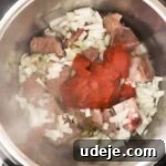 Effortless Green Bean Stew Instant Pot and Stovetop 17 cut green beans with veal, tomato paste and onions in the instant pot on a light marble background