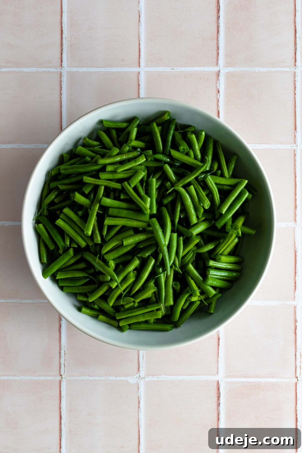 Effortless Green Bean Stew Instant Pot and Stovetop 4 freshly trimmed and cut green beans in a blue bowl, ready for cooking