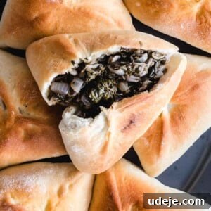 Spinach fatayer on a platter with the top one open to reveal spinach and onion stuffing