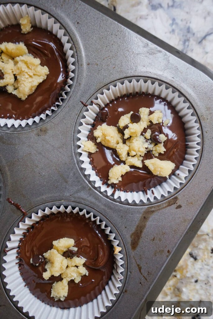 Freshly prepared Vegan Chocolate Chip Cookie Dough Yogurt Cups in a muffin pan, ready for freezing.